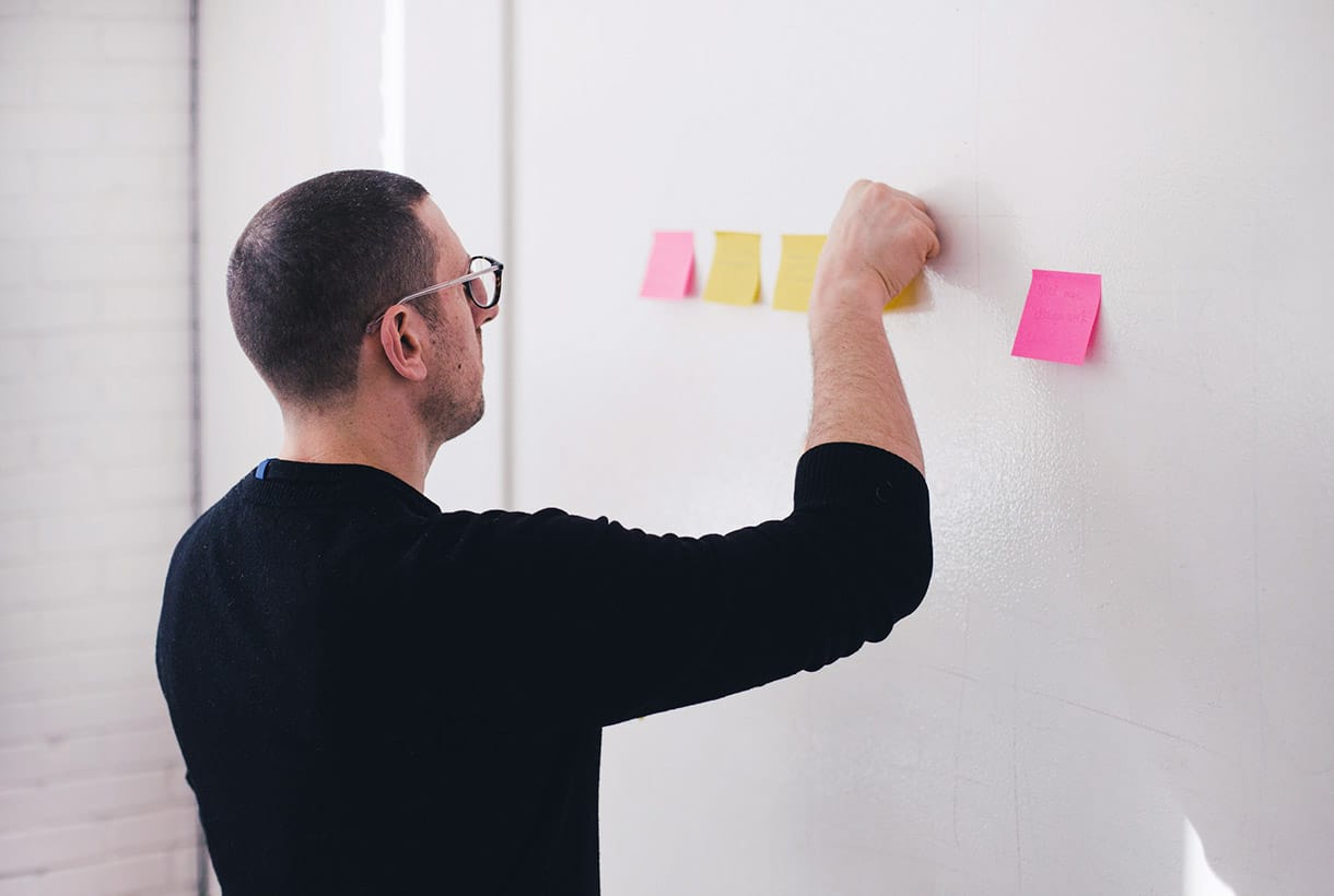 A lecturer posting notes on a whiteboard